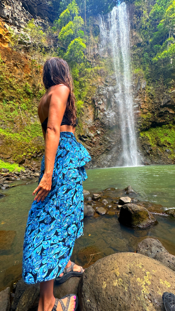 Woman in sarong looking at waterfall