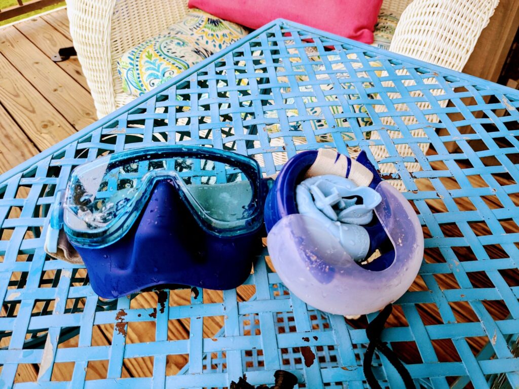 Rolled up snorkel and mask on outdoor table