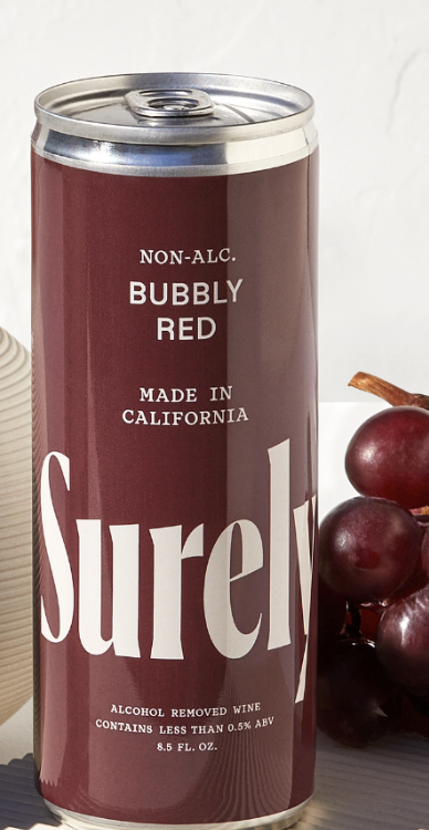 Can of Surely Red Bubbly NA Wine next to grapes