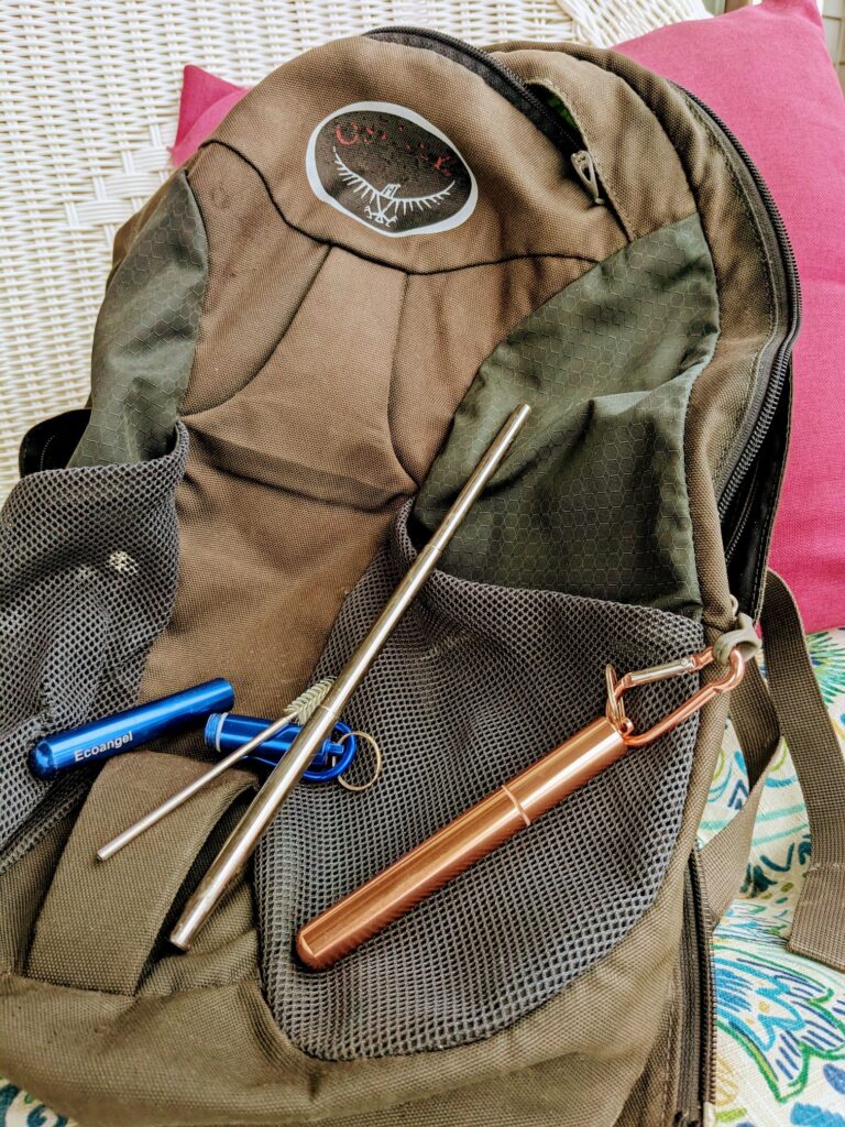 Collapsible straws clipped to backpack